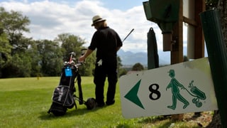 Ein Mann spielt Golf auf einem Golfplatz. 