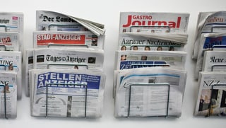Mehrere Wandhalterungen mit Zeitungen