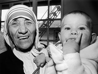 Mutter Teresa hält ein neunmonatiges Schweizer Mädchen während einer Segnungszeremonie.