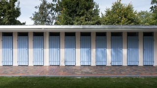 In einer geschlossenen Freiluft-Badi sieht man die leeren Umzugskabinen. In einer geschlossenen Freiluft-Badi sieht man die leeren Umzugskabinen.