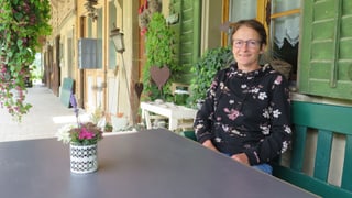 Eine Frau sitzt an einem Tisch. Eine Frau sitzt an einem Tisch.