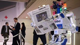 Ein Roboter mit Zeitung am WEF.