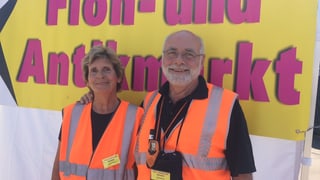 Mann und Frau vor Schild Mann und Frau vor Schild
