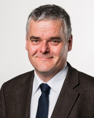 Christian Fuhrmeister mit Krawatte und Anzug lächelt in die Kamera. Christian Fuhrmeister mit Krawatte und Anzug lächelt in die Kamera.