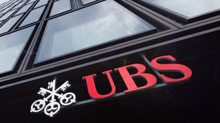 UBS-Logo, angebracht unten an einem Filialgebäude mit Glasfassade