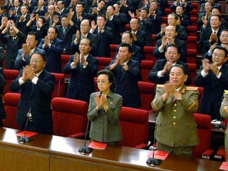 Kim Kyung Hee inmitten von zahlreichen Männern in Uniform