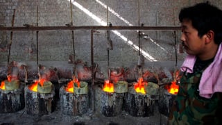 Ein Arbeiter in einer Fabrik in der Mongolei überwacht Behälter, die das Seltene-Erden-Element Lanthanum enthalten.