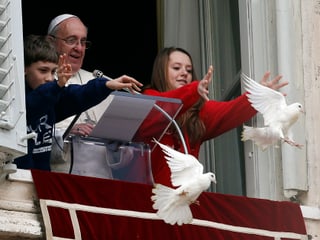 Der Papst mit zwei Kindern, die zwei weisse Tauben fliegen lassen.