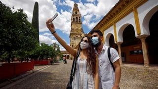 Zwei junge Personen mit Mundschutz machen Selfie in Cordoba.