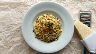 Ein Teller mit Spaghetti mit Olivenöl-Brösmeli, Kapern und Sardellen.