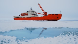 Rot-weisses Schiff, im Vordergrund Eis und Wassertümpel