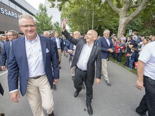Maurer winkt Zuschauenden am Festumzug zu.