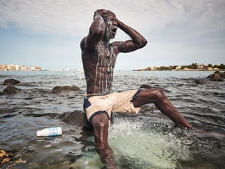 Ritual vor dem Kampf: Ein junger Wrestler übergiesst sich im Meer mit Milch.