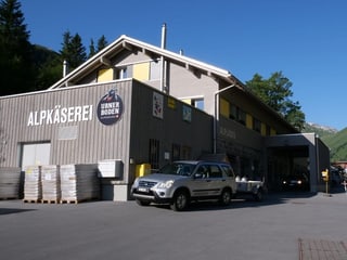 Ein graues Haus, das die Aufschrift «Alpkäserei Urnerboden» träft. 