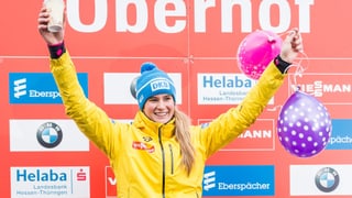 Natalie Geisenberger mit Geburtstags-Ballonen auf dem Siegerpodest.