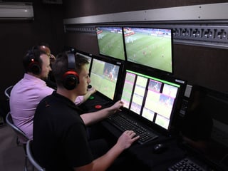 Drei Video-Assistenten in einem Raum mit mehreren Bildschirmen