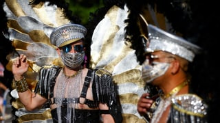 Zwei Männer in Verkleidung und mit Gesichtsmasken.