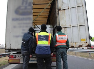 Polizisten kontrollieren die Ladung eines LKW.