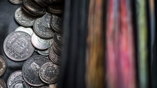 Schweizer Münzen links und Banknoten rechts.