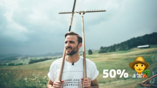 Ein Mann hält eine Mistgabel und einen Rechen in der Hand Ein Mann hält eine Mistgabel und einen Rechen in der Hand