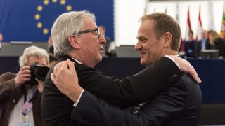 EU-Ratspräsident Tusk und EU-Kommissionspräsident Juncker halten sich in den Armen.
