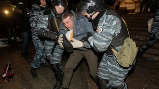Ukrainische Polizisten nehmen einen Aktivisten fest.