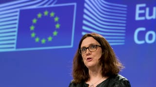 Cecilia Malmström vor einer blauen Wand mit dem EU-Logo. 