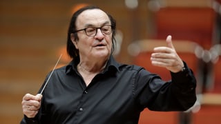 Charles Dutoit mit dem Dirigierstock. Er trägt ein schwarzes Hemd.