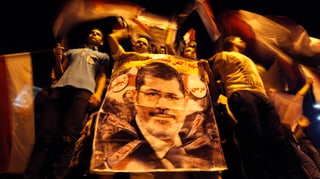 Anhänger von Mursi mit einem Plakat