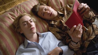 junger Mann liest einer Frau vor - sie liegen nebeneinander 