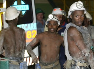 Vier Minenarbeiter mit Schmutz verschmiert.