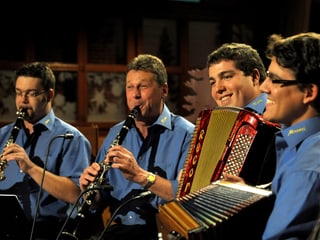 Vier Volksmusikanten in blauen Hemden.