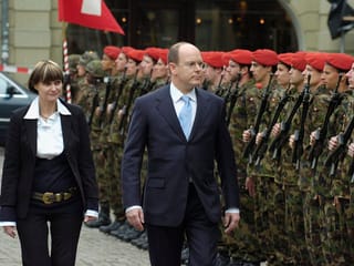 Calmy-Rey und Albert II. schreiten eine Ehrengarde ab.