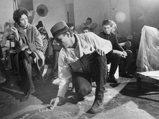 Beuys zeichnet etwas auf den Boden, Studenten beobachten ihn interessiert. Beuys zeichnet etwas auf den Boden, Studenten beobachten ihn interessiert.