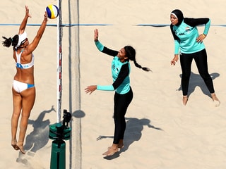 Die ägyptischen Beachvolleyballerinnen in langen Kleidern, eine mit Kopftuch, die Deutschen im Bikini, am Netz.