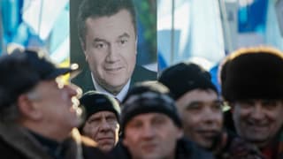 Janukowitschs Befürworter mit blauen Fahnen und Schildern mit dem Portrait des Präsidenten.