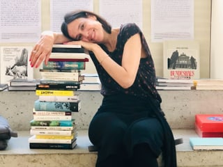 Annette König neben einem Stapel Bücher