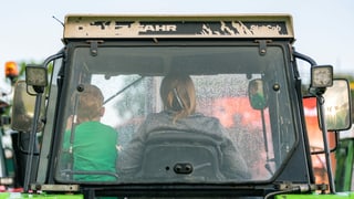 Bäuerin mit Kind in einem Traktor