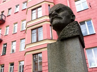 Leninbüste vor einer pinken Hausfassade.