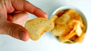 Eine Hand hält ein Pommes Chips