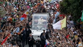Papst Franziskus fährt im Papamobil durch die Menge.
