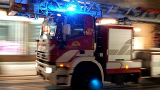 Ein Feuerwehrauto ist mit Blaulicht unterwegs