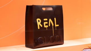 Bild einer schwarzen Handtasche vor orangem Hintergrund