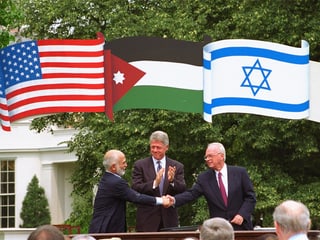 Rabin und Hussein reichen sich die Hand, darüber die Flaggen der Länder.
