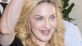 Madonna lächelnd mit Goldzähnen.