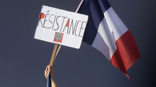 Eine Tricolore und ein Plakat mit der Aufschrift Resistance (Widerstand).