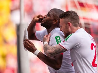 Anthony Modeste jubelt nach seinem Führungstreffer für den 1. FC Köln gegen Arminia Bielefeld mit seiner eigenen Kaffee-Röstung und hält die Verpackung in die Kamera.