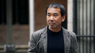 Murakami steht draussen vor einem Gebäude.