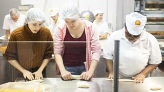 Zwei junge Frauen versuchen sich in der Bäcker-Arbeit an der Berufsmesse Zürich