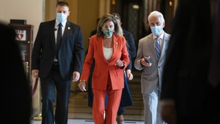 Nancy Pelosi unterwegs mit zwei Personen - alle tragen Masken.